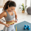 Woman measuring waistline as part of a personalized weight loss in Ellicott MD
