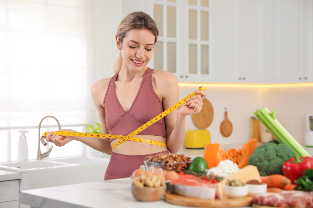 Woman measuring waist while preparing healthy foods at a weight loss clinic near Columbia MD