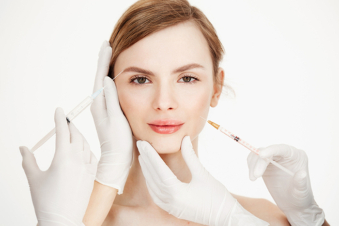 Woman receiving botox injections for wrinkles on forehead and facial lines